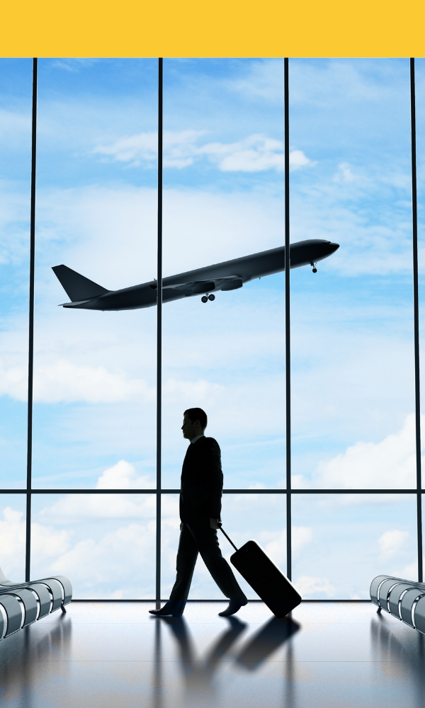 Silhouette of a traveller with luggage in an airport terminal as a plane takes off